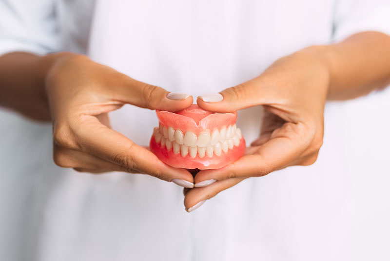 Dentist Holding dentures